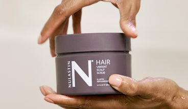 A woman's hand holding NULASTIN's new Vibrant Scalp Scrub