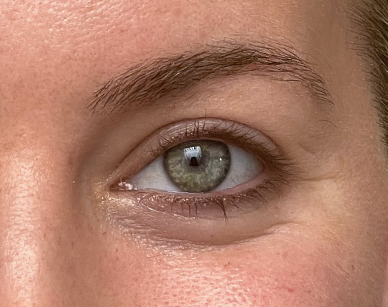 Close up of woman's eye with fuller looking lashes after using Nulastin's LASH Follicle Fortifying Serum