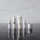 NULASTIN travel size collection on wet reflective surface