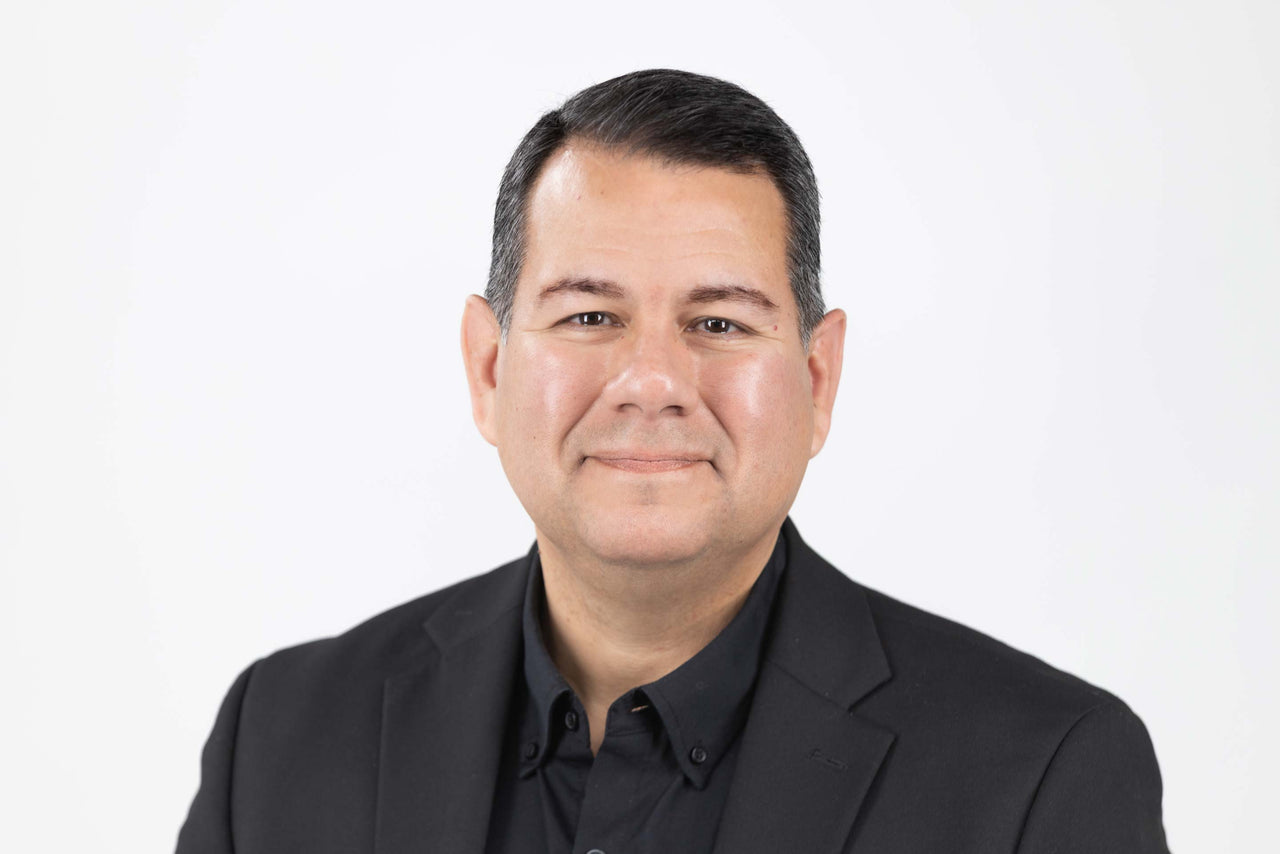 Picture of Dr Felipe Jimenez PhD in a sharp black suit smiling and looking professional