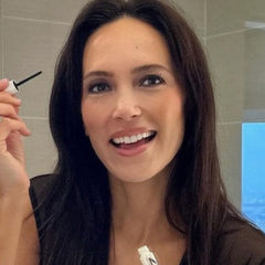 UGC creator applying Nulastin Lash serum in black dress