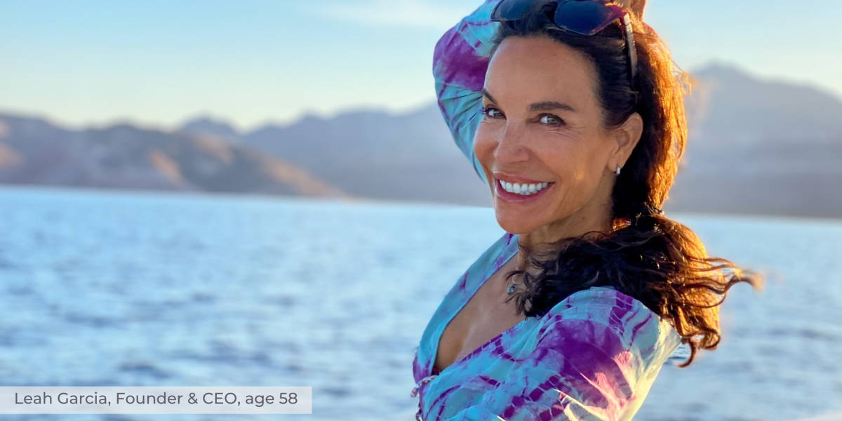 Smiling woman posing by a lake at sunset with mountains behind her, overlay text 'Leah Garcia, Founder & CEO, age 58'