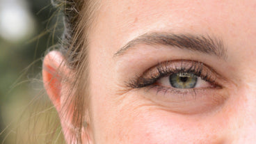 Close-up of a woman's right eye showing fuller, longer upper eyelashes and natural eyebrow after three weeks of lash serum