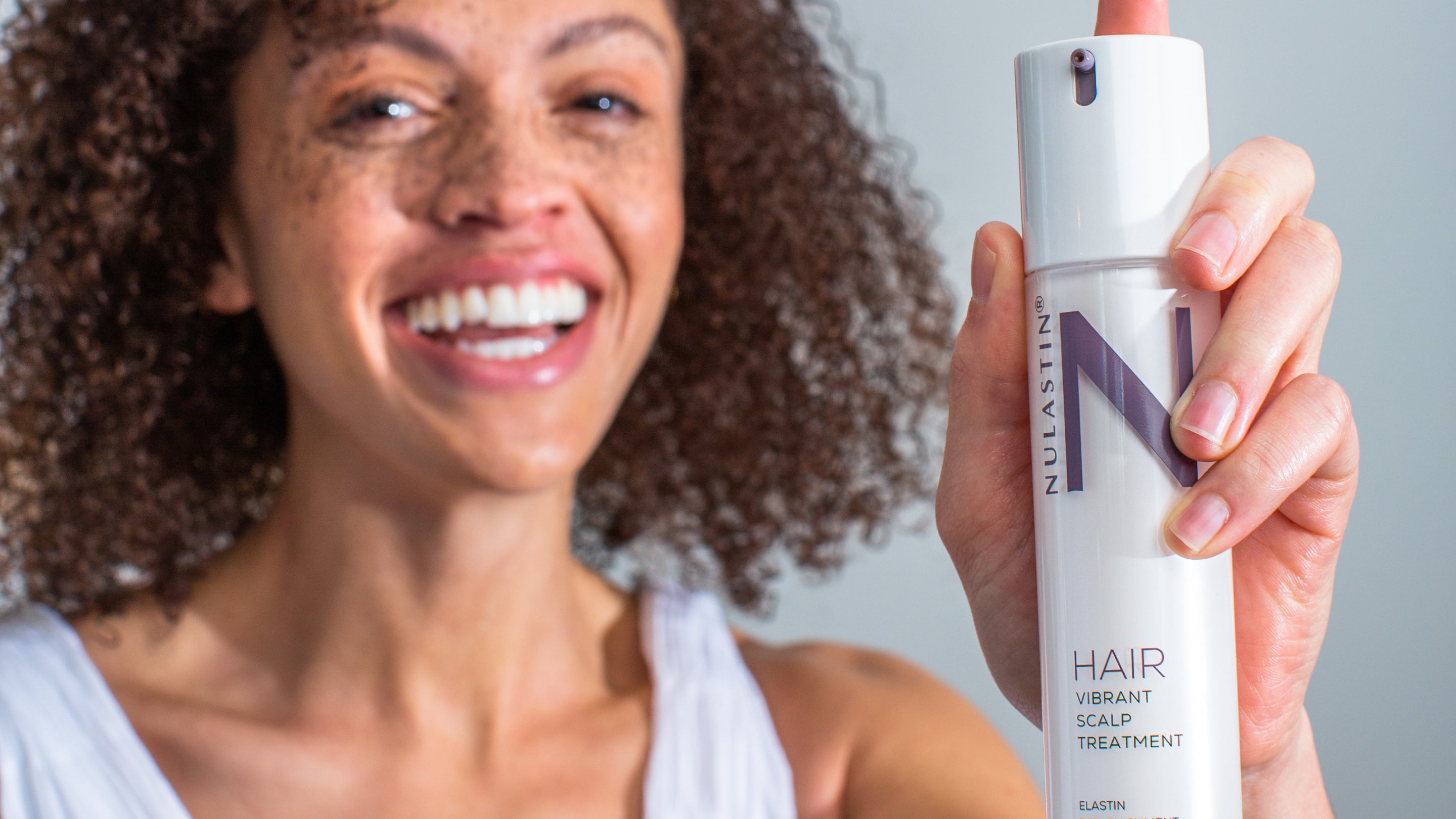 Woman holding NULASTIN HAIR Vibrant Scalp Treatment. 3 ways to upgrade your hair washing routine.