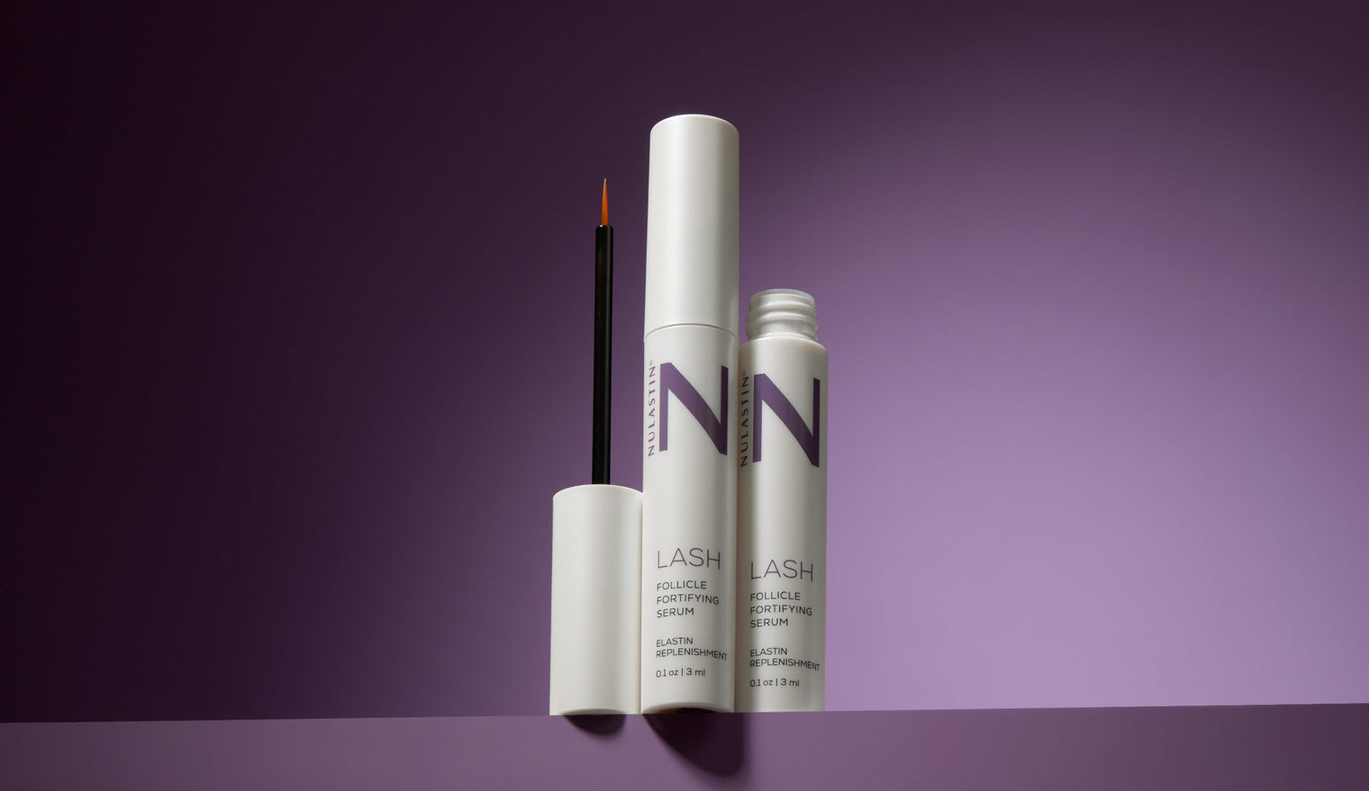 Two bottles of NULASTIN LASH serum with a beautiful purple background.