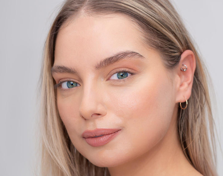 Young woman with great brows smiling at the camera 