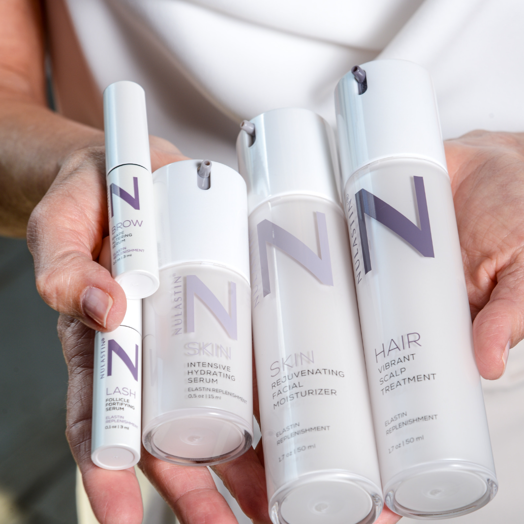 Hands holding Skin, Brow, Lash and Hair NULASTIN products 