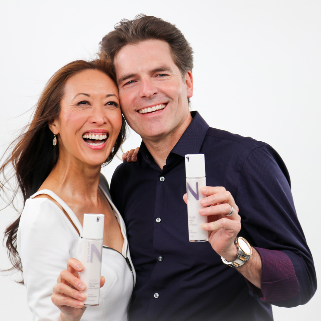 Smiling woman and man holding NULASTIN products against white background 