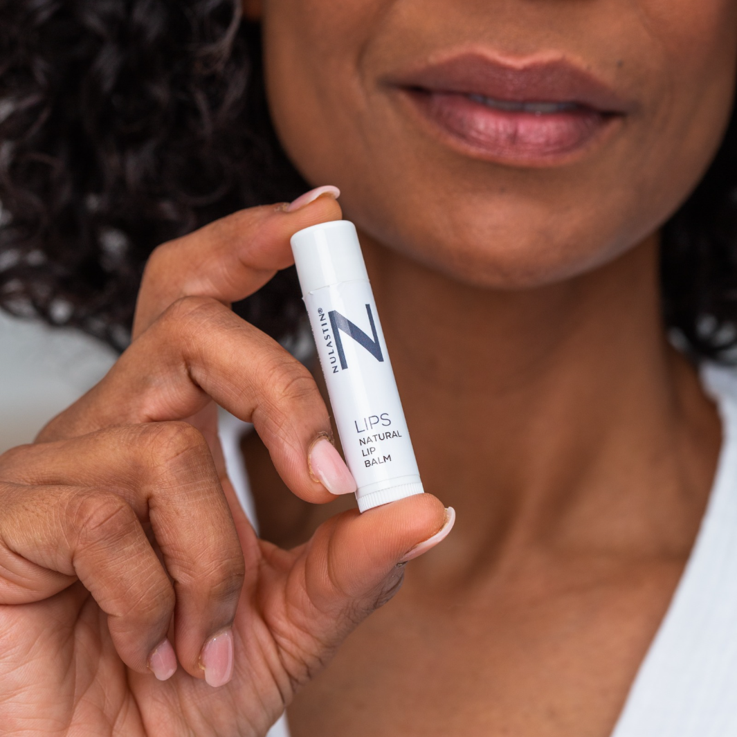 Woman holding white NULASTIN natural lip balm