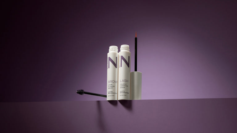 Nulastin Lash and Brow Serums on ledge with purple background