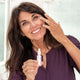 Woman applying one of the travel skincare products 