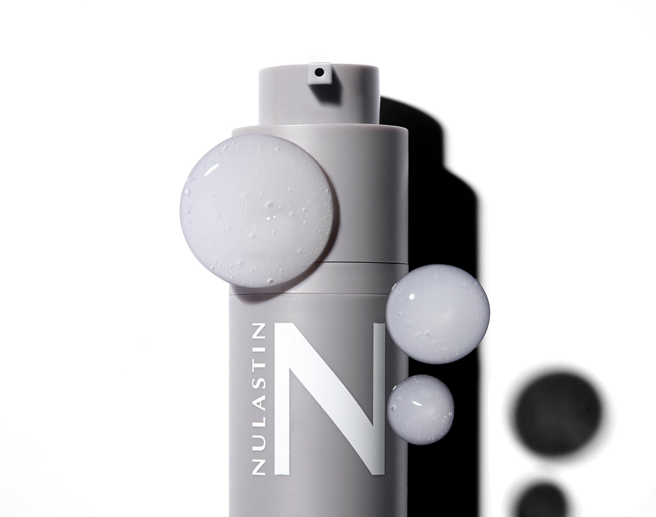 Front close up of Dermal Rejuvenating Moisturizer bottle with airless pump, cream smear, matte gray color and large N logo